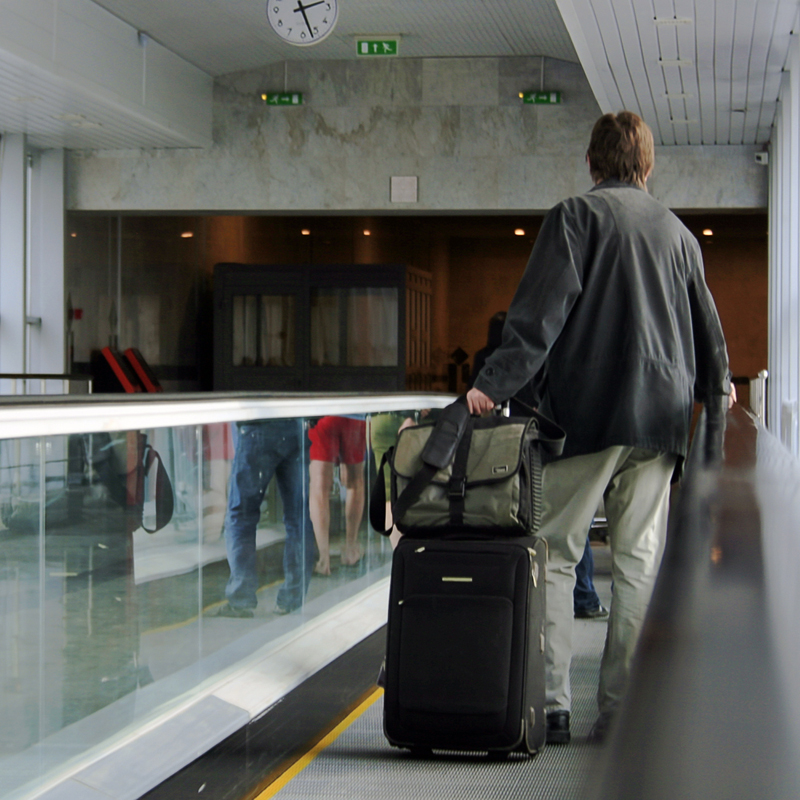 homme tirant sa valise dans un aéroport