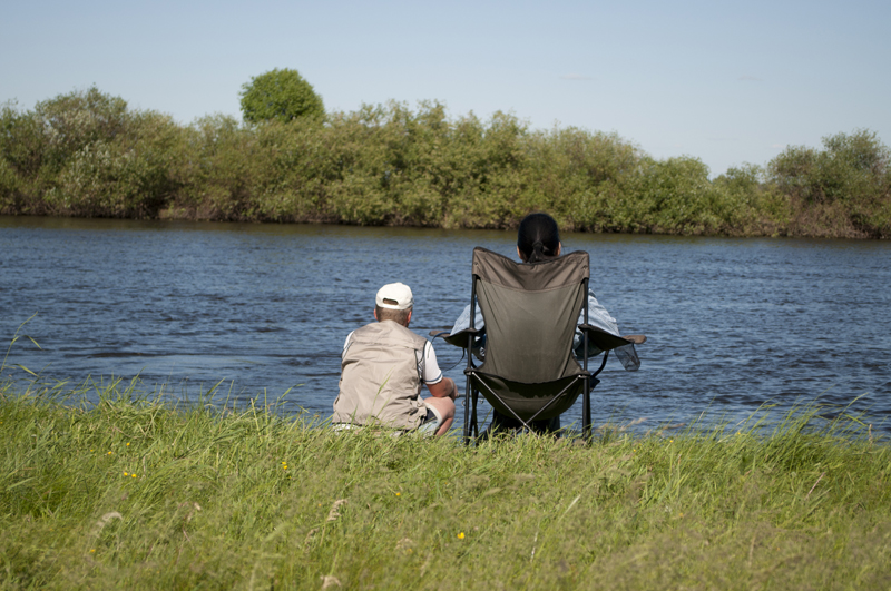 deux personnes péchant au bord d'un lac ou d'une rivière